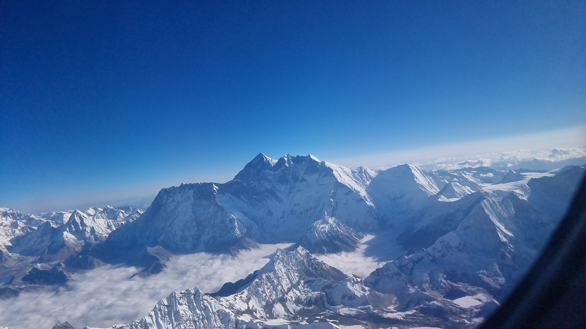 Aerial view of towering snow-capped mountain peaks.