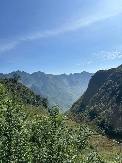 Mountainous landscape with clear blue sky and lush greenery.