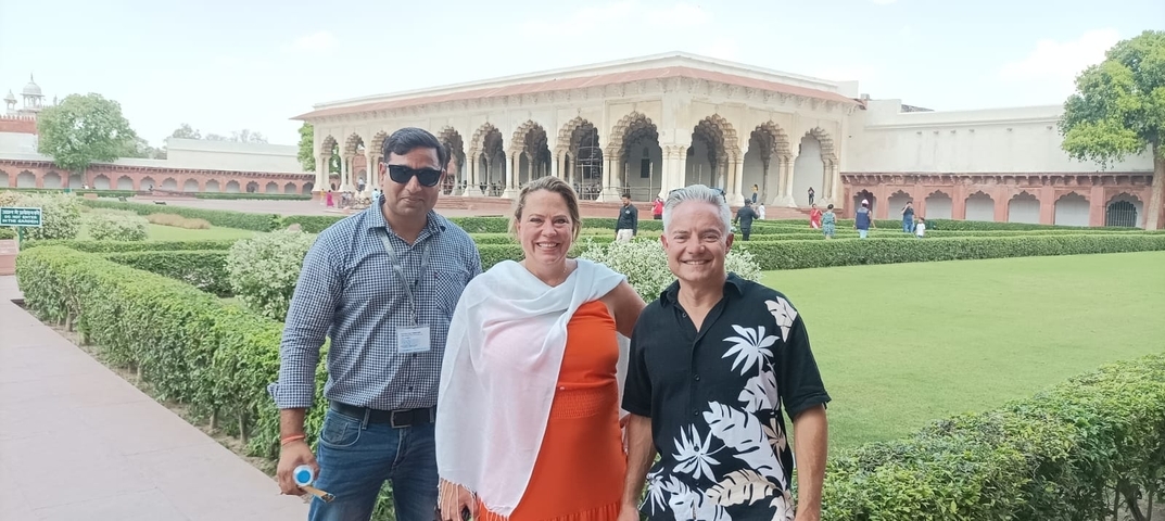       Three people posing in front of a historic building.
  