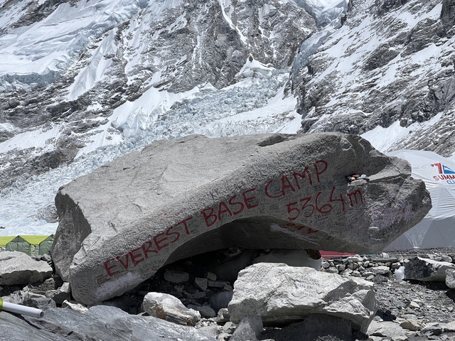 Engraved rock at Everest Base Camp surrounded by snow.