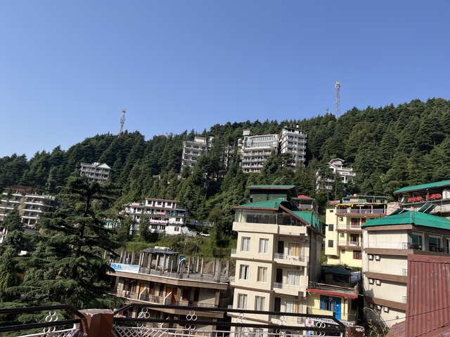 Hilltop view with tree-covered slopes and buildings.