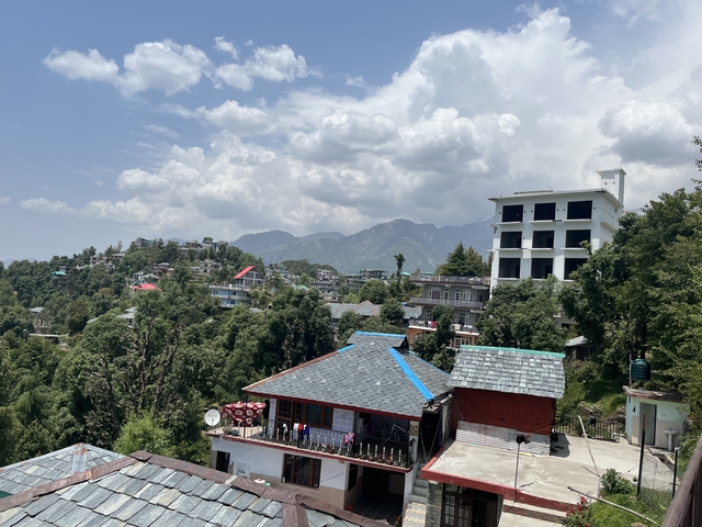 Mountain view with clouds and scattered buildings.