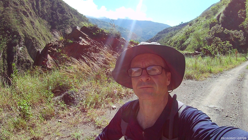 Man taking a selfie on a mountainous trail.