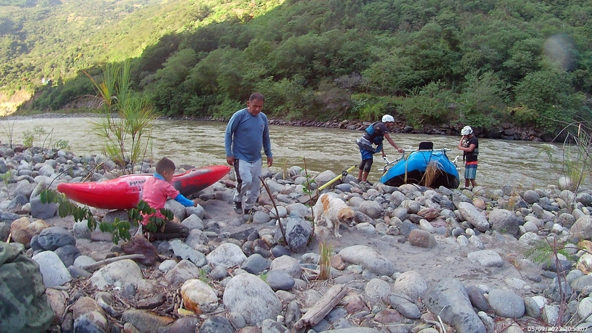 People preparing kayaks by a river.