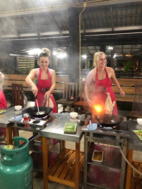 Two women cooking at a food stall.