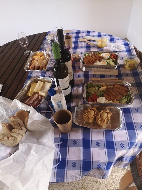 Assorted food and drinks set on a checkered tablecloth.