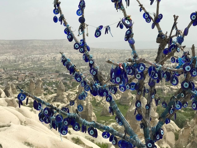 Decorative tree covered with blue charms overlooking a valley.