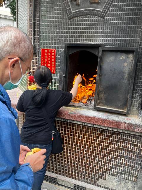       Person inserting an item into an oven with flames.
  
