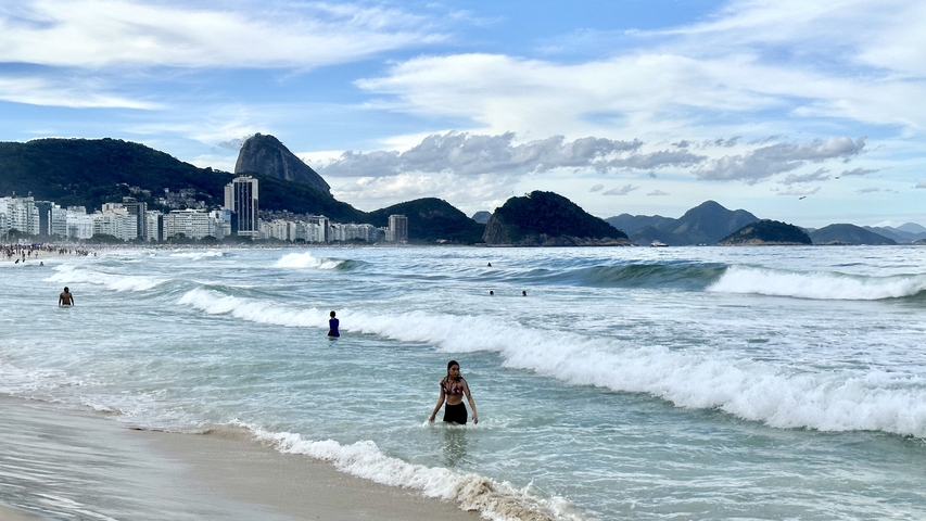 Beach with waves and people enjoying the water.
