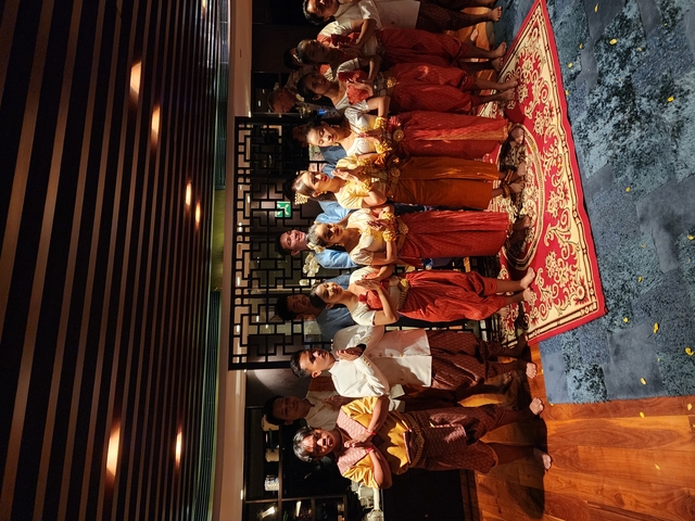 Group of people in traditional attire posing indoors.