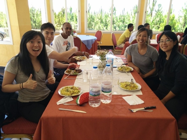       Group dining at a restaurant, enjoying a meal.
  