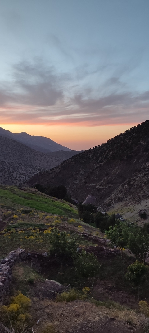       Mountain view at sunset with silhouetted peaks.
  