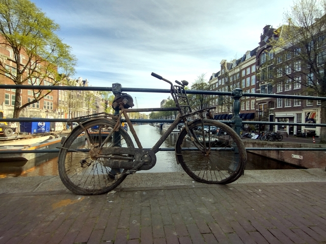 Old bicycle on a canal bridge in Amsterdam.