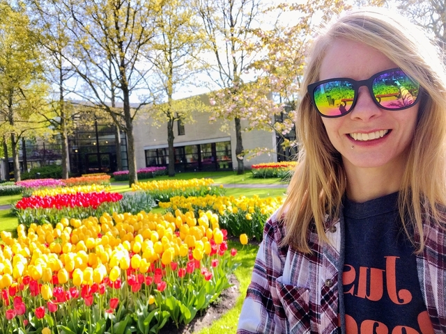       Person smiling among colorful tulips.
  