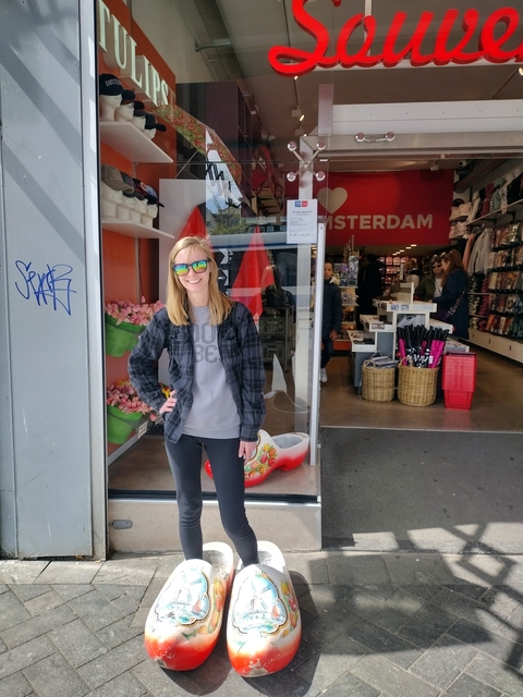 Smiling woman standing in front of a souvenir shop.