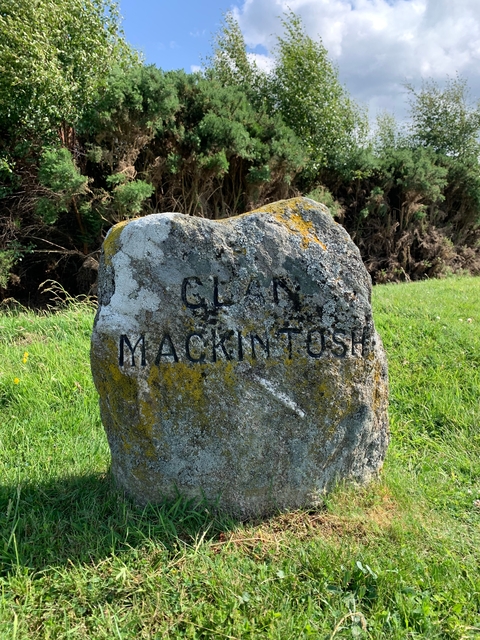 Rock with 'Clan Mackintosh' inscribed on it in the grass.