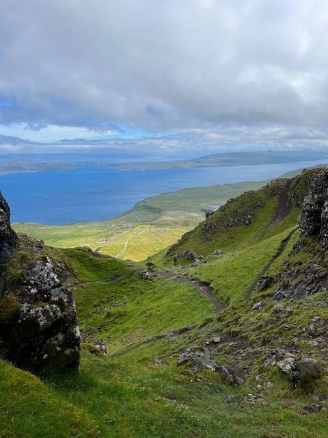 Hills and coastline with an expansive view of the sea.