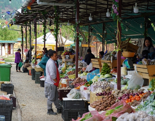       A bustling market scene with various produce and people.
  
