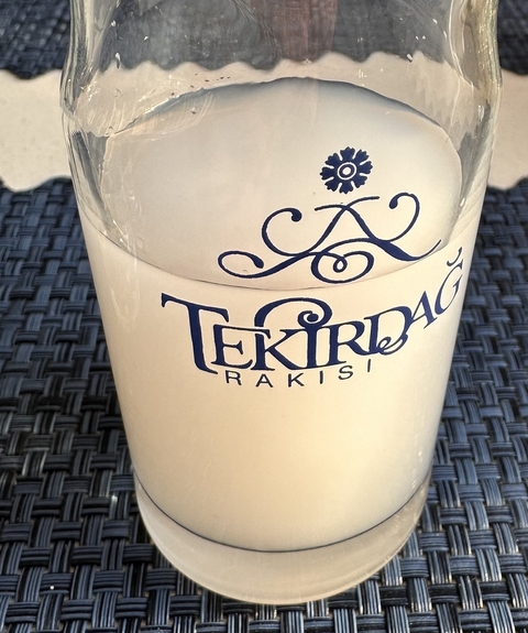       A glass of Tekirdağ Rakısı placed on a woven mat.
  