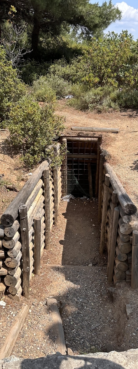 A historical trench entrance with wooden reinforcements.