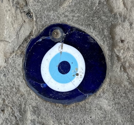       A decorative eye design embedded in a rock surface.
  