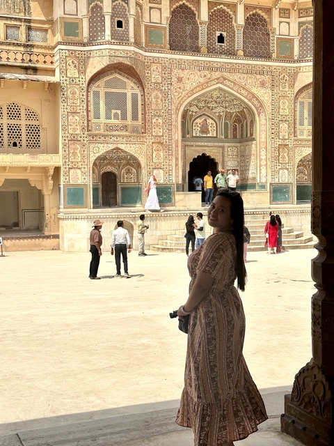       A historical site with intricate architecture and people walking.
  