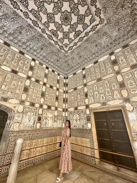       A historical building with detailed carvings and a person posing.
  