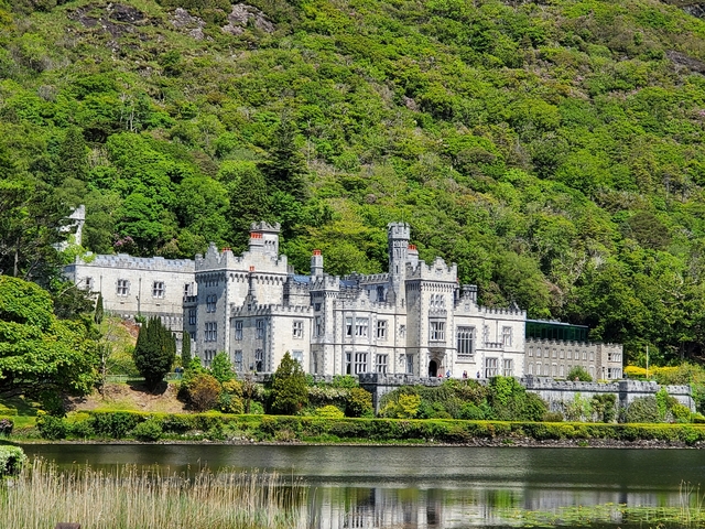 Scenic view of a castle amidst lush green hills.