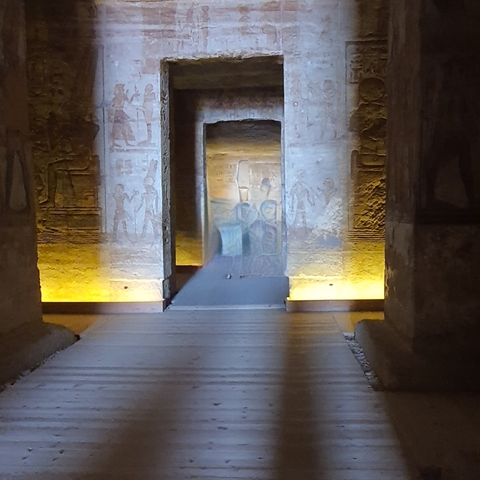 An ancient interior with hieroglyphics and illuminated paths.