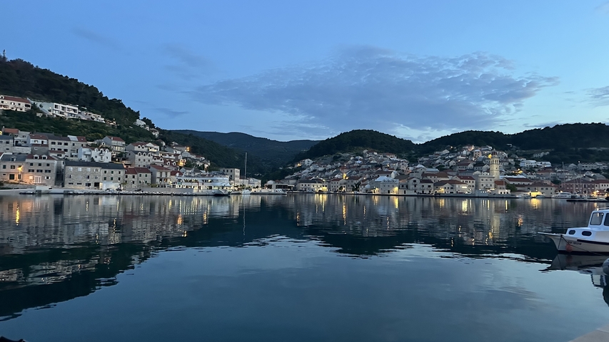 A picturesque coastal village at dusk with reflections in the water.