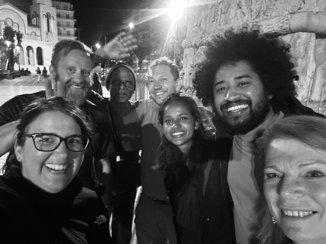       A group of people posing for a black and white photo at night.
  