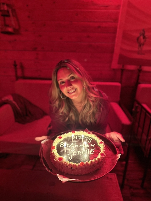 Person holding a cake with 'Happy' written on it