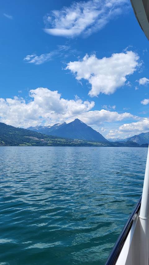 Lake with mountain backdrop under a clear blue sky.