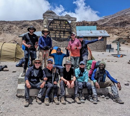 Group of hikers posing at a high altitude mountain campsite.