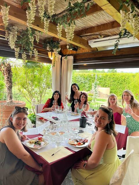 Group of women enjoying a meal and wine at a restaurant.
