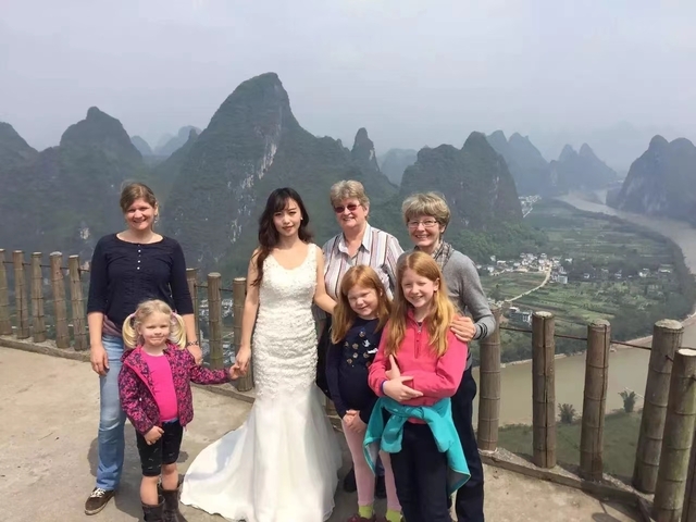 Group of people posing with a scenic Yangshuo background.
