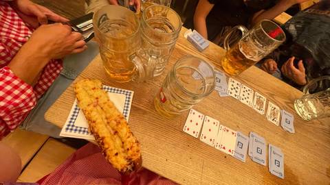       Table with beer steins and playing cards.
  