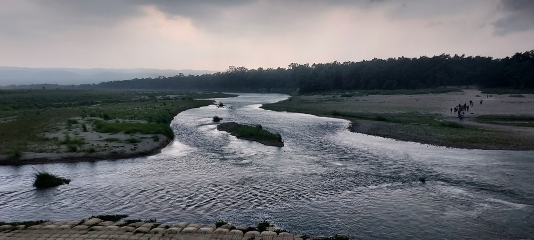 Winding river through a landscape with distant hills.