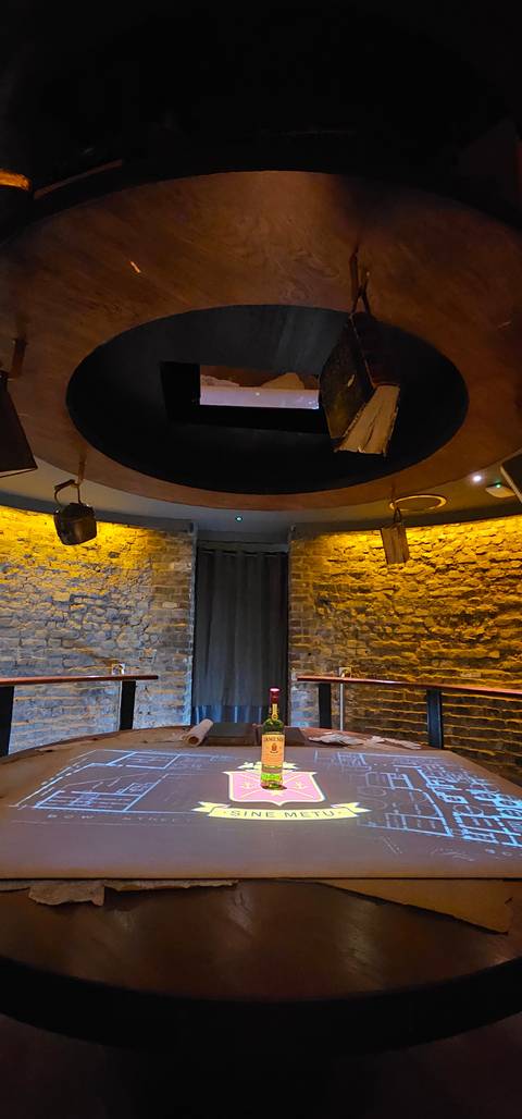 Round table setting with illuminated screen in dimly lit room.