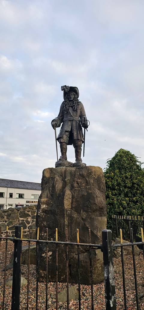Statue of a historical figure in a small village setting.