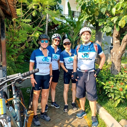Cyclists posing outdoors with a bicycle