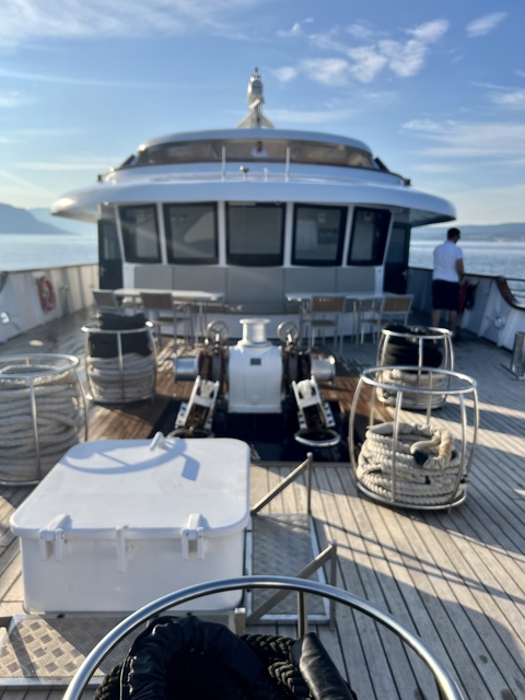 Blurry view of a ship's deck equipment with people standing.