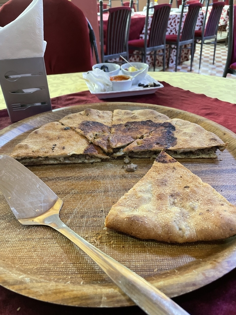       Piece of flatbread on a wooden platter.
  