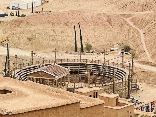       Circular arena in a desert setting with green spaces.
  