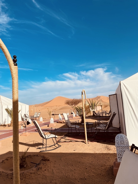       Desert camp with modern tents and amenities.
  