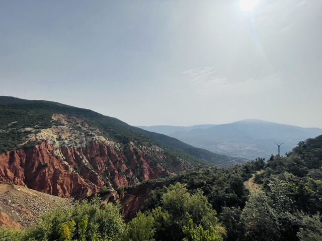 Mountain scenery with red and green rock formations.