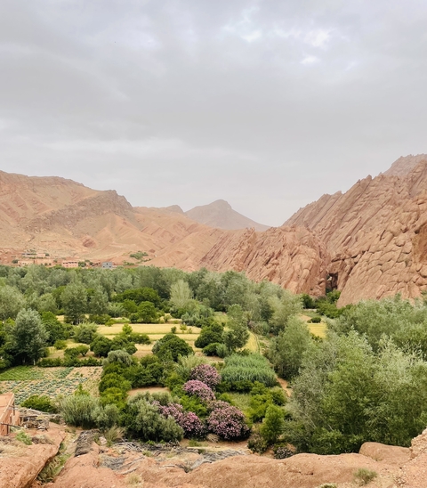 Jagged mountains with lush valleys and traditional dwellings.