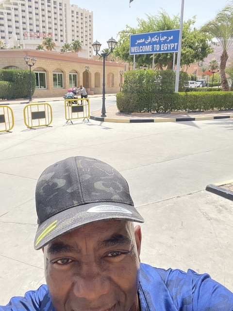 Close-up view of a person in front with a bright street background.