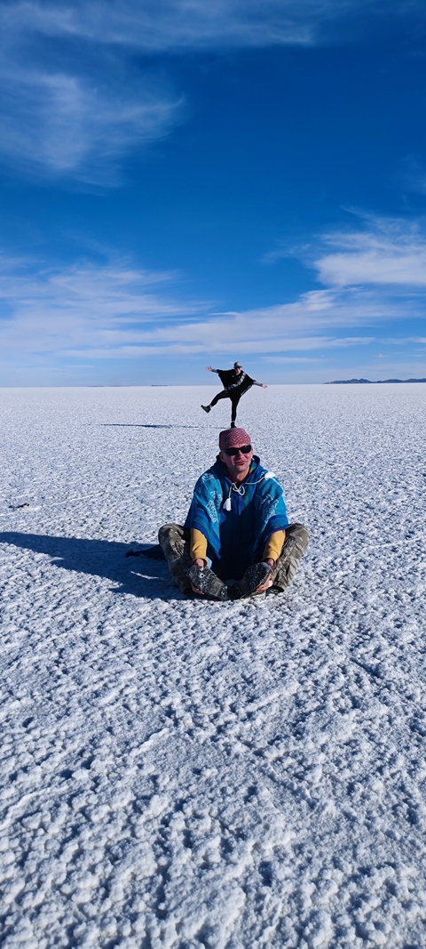 Two people posing creatively on the Uyuni Salt Flat.