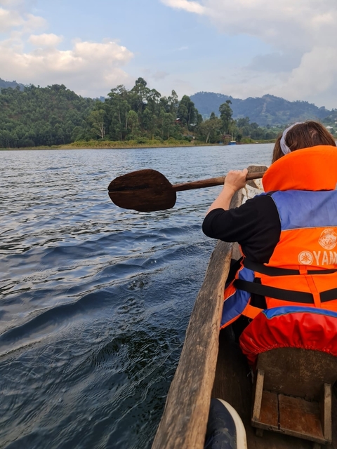       Person paddling a wooden canoe on a lake
  